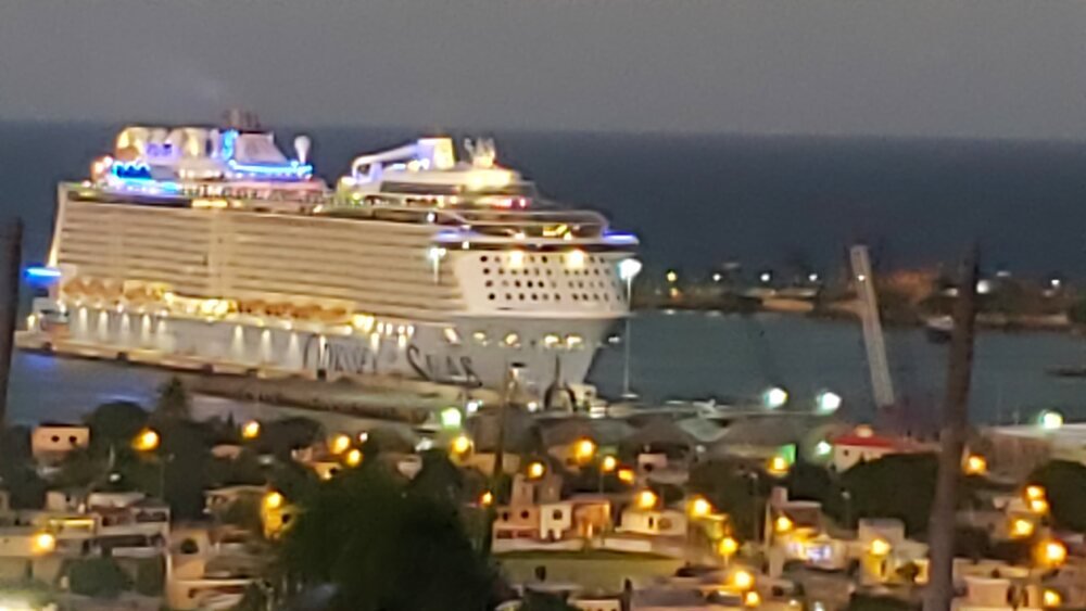 Cruise ship lit up in port at dusk