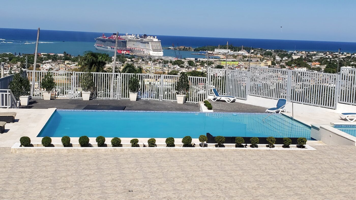 Infinity pool with cruise ship and port views